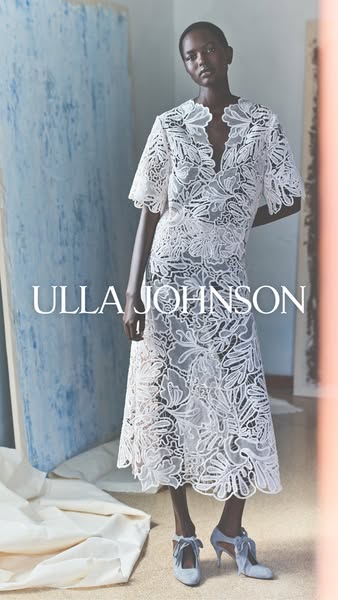 An image showcases a Black model in a white Ulla Johnson dress. The brand name is overlaid in white text on the image.