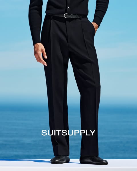This is an image ad promoting SuitSupply black dress pants. The ad emphasizes the elegance of the pants with a simple de