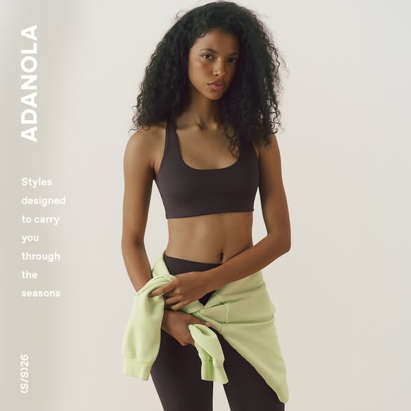 This Adanola image ad features a woman wearing a matching athleisure set with a sweatshirt casually draped over her shou