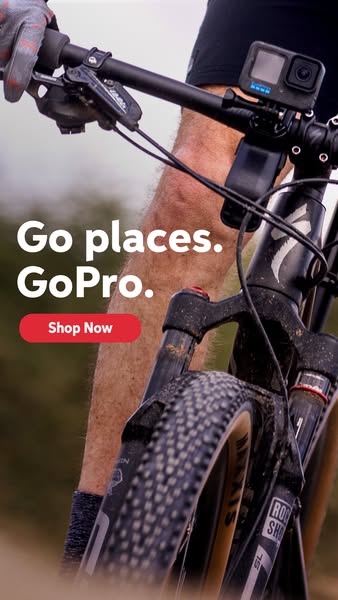 This ad features a close-up shot of a mountain biker riding on a trail, with a GoPro camera mounted on the handlebars. T
