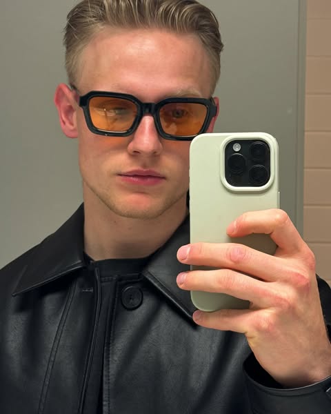 The ad features a person wearing black-framed sunglasses with orange lenses, taking a selfie. The focus is on showcasing