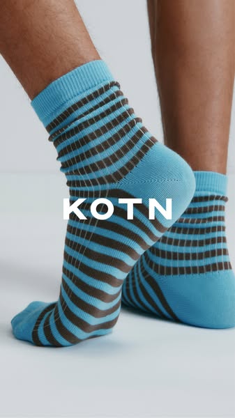 This image ad by KOTN features a close up studio shot of a pair of socks being worn on a neutral surface. The brand name