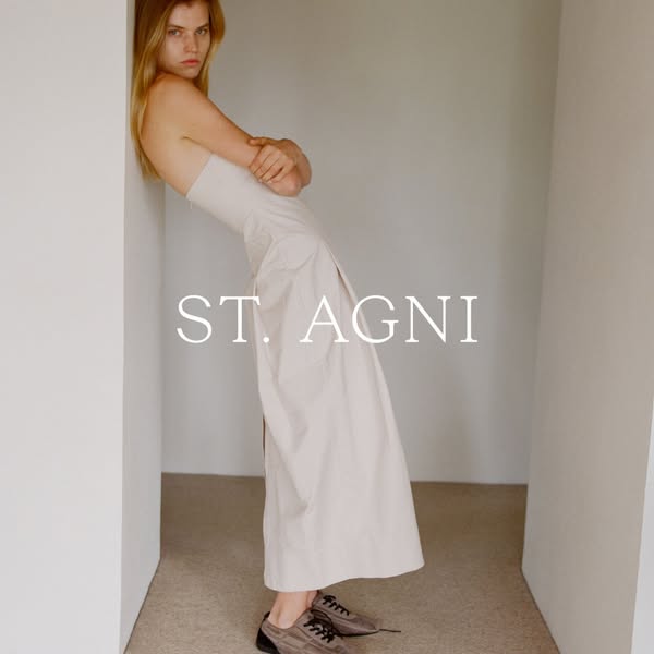 This ad for ST. AGNI features a model leaning against a wall, showcasing a dress from the brand. The ad is minimalistic