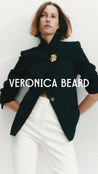 This ad showcases a woman wearing a black Veronica Beard blazer and white pants.