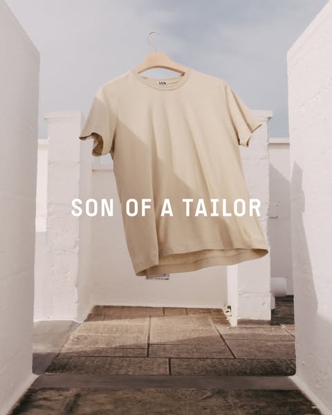 This image ad showcases a khaki-colored t-shirt from the brand Son of a Tailor. The t-shirt is presented hanging against