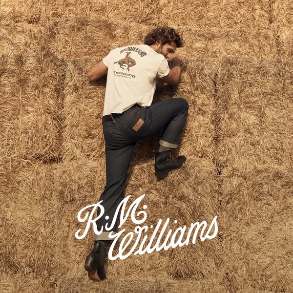 This ad features a man on a haystack wearing R.M. Williams jeans and boots. The ad is designed to convey a rustic, class