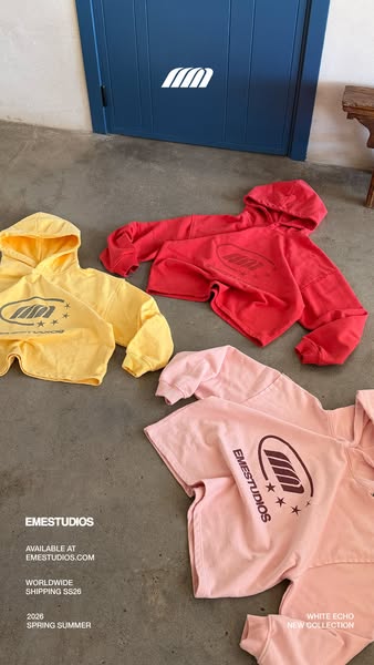 This image ad showcases three different colored hoodies from EMESTUDIOS. The hoodies are displayed on the floor, and tex