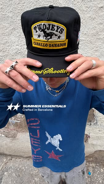 The ad features a person in a blue, long-sleeved shirt and grey pants, wearing a black baseball cap with a prominent log