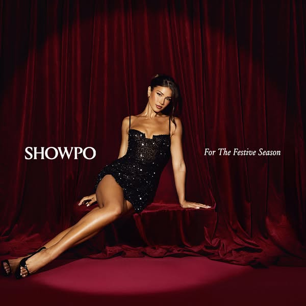 This image ad for Showpo features a model in a black sequin dress, posed against a red velvet backdrop, promoting festiv