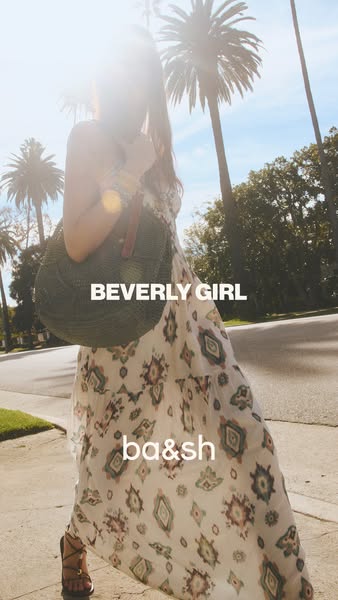 This image ad features a woman in a summery dress and bag from ba&sh, set against a sunny backdrop with palm trees t