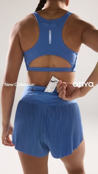 This ad showcases a woman wearing a matching blue athletic set. She is putting a small silver packet into the zipper poc