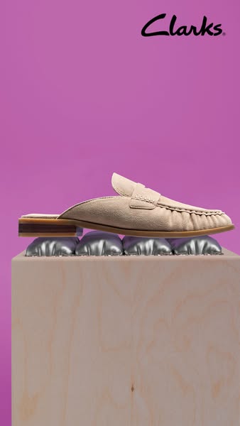 This ad showcases a single beige slide shoe, elevating it on a pedestal with silver bubble wrap. The backdrop is solid p