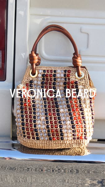 This image ad showcases a Veronica Beard handbag against a white vehicle.