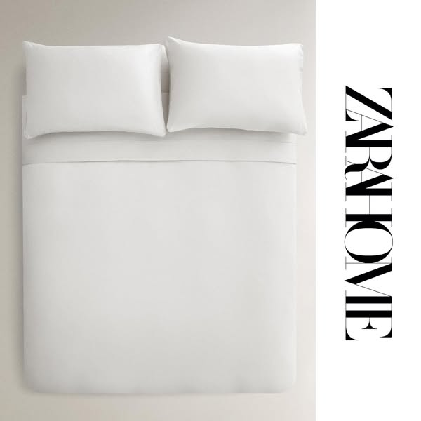 This ad showcases a neatly made bed with white linens from Zara Home, emphasizing the brand's minimalist aesthetic a