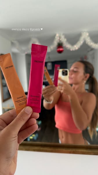 This ad features a woman holding up two Promix drink mixes while taking a selfie to advertise the brand.