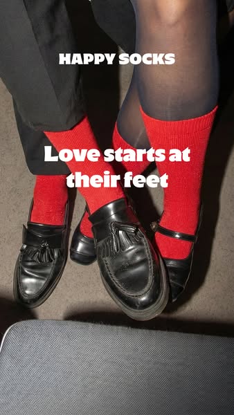 This image showcases a brand of socks called Happy Socks. The image shows two sets of feet dressed in red Happy Socks an