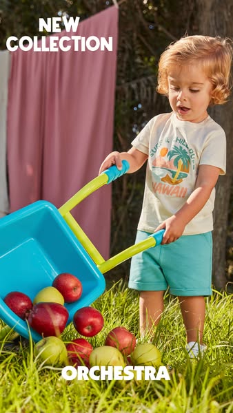 This image ad promotes the new collection from Orchestra, showcasing a young child playing with a toy wheelbarrow full o