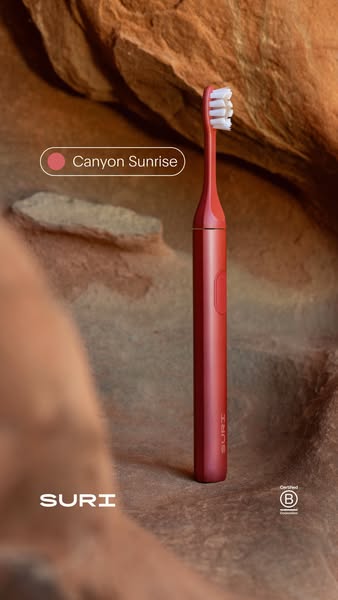 This ad showcases a red electric toothbrush in front of a canyon wall background, emphasizing the product's color an