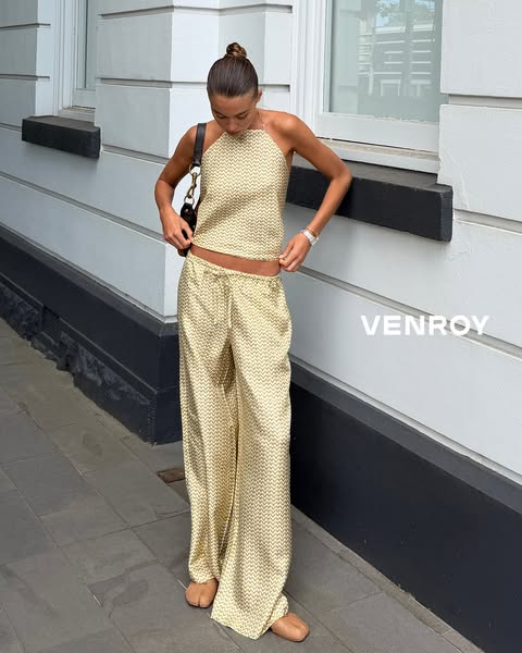 A woman models a matching set of a halter top and palazzo pants. The text reads "VENROY."