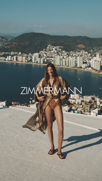 This Zimmerman ad features a model wearing a patterned swimsuit and a matching robe, set against a backdrop of a coastal