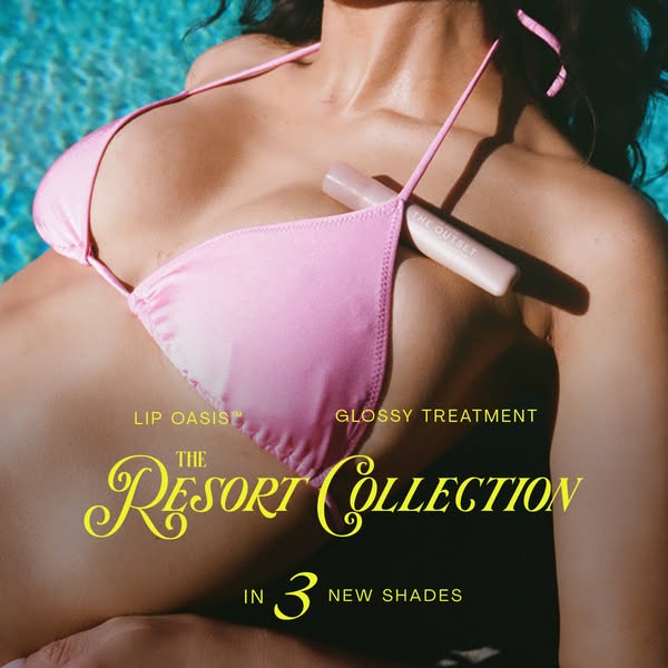 The Outset image ad shows a woman in a bikini laying in the sun, a tube of Lip Oasis Glossy Treatment sits between her b