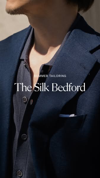 A close-up shot of a man wearing a navy blazer and matching shirt, accompanied by the text "Summer Tailoring" 