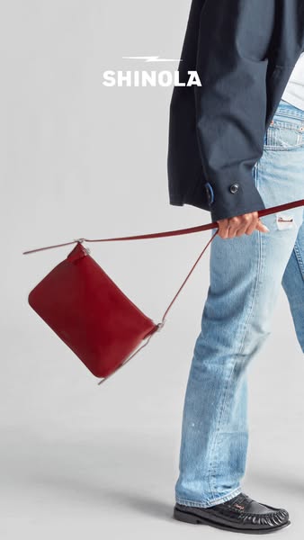 This ad features a red Shinola bag being worn crossbody. The ad includes the brand name at the top of the image.