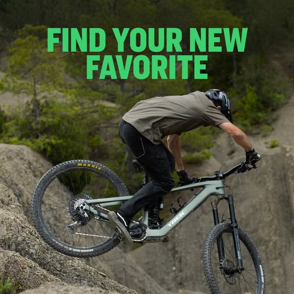 A man riding a bike down a rocky hill surrounded by nature with green text overlaid on the image.