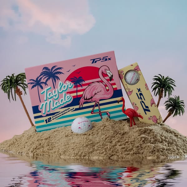 The ad features a box of TaylorMade TP5x golf balls on a sand dune in the ocean, with palm trees and a blue and pink sun