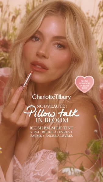 This ad features a blonde woman applying Charlotte Tilbury's Pillow Talk In Bloom blush balm lip tint. A pink heart 
