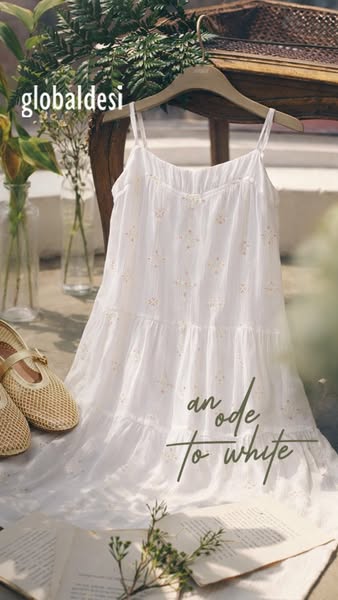This ad showcases a Global Desi white dress, styled in a visually appealing setting with natural light, greenery, and co