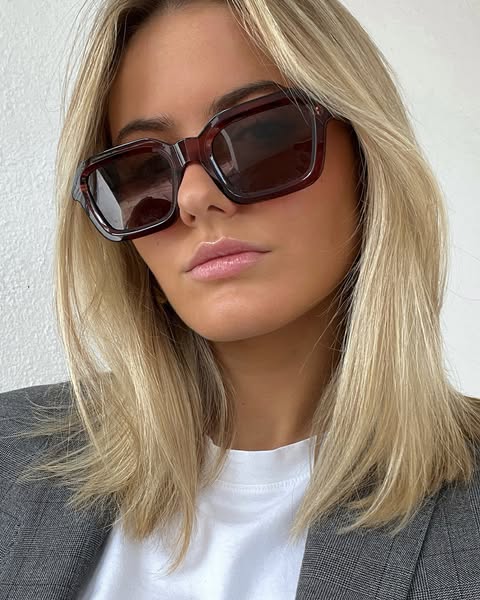 This ad features a woman wearing sunglasses. The photo is a medium shot and appears to be taken in a natural light setti