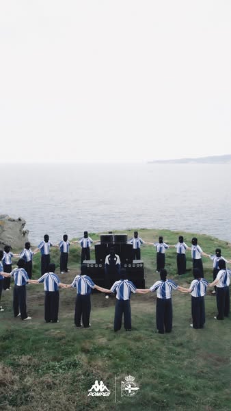 This ad shows a circle of people holding hands on a grassy cliff overlooking the ocean. The people are wearing matching 