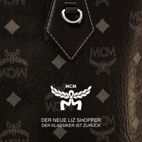 The ad displays a close up shot of an MCM Liz Shopper bag, patterned with the brand's logo, and text announcing the 