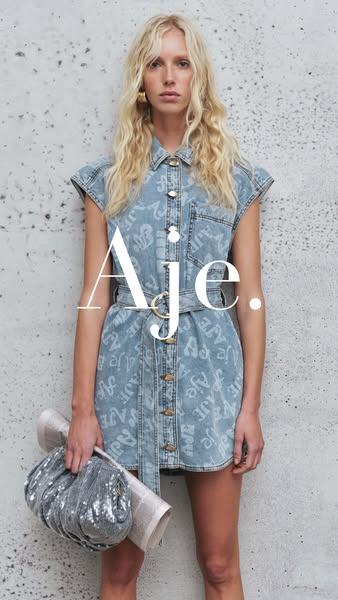 This ad features a woman wearing a denim dress with the brand name printed on it. She is holding a newspaper and a silve