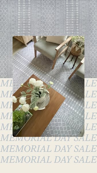 This ad features an indoor room scene with a light gray and white patterned area rug under a coffee table and chairs. Th