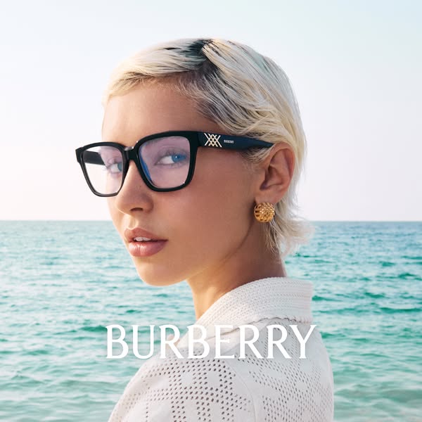 This ad showcases Burberry eyewear. A woman is wearing the glasses, standing in front of the ocean. The Burberry brand n