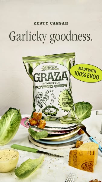 This image ad promotes Graza Zesty Caesar Homestyle Potato Chips. The ad features a bag of the chips surrounded by ingre