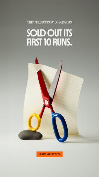 The ad features a pair of scissors seemingly cutting a lined piece of paper, set against a gray background. Text at the 