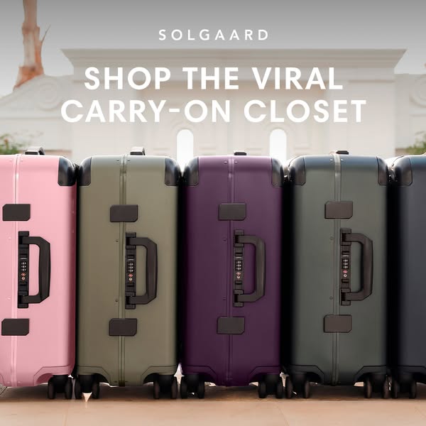 This image ad showcases five Solgaard carry-on suitcases in different colors against a blurred architectural background.