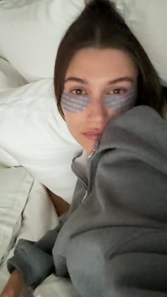 This ad features a woman lying in bed wearing eye patches. The ad is likely for an eye care product, and the woman is de