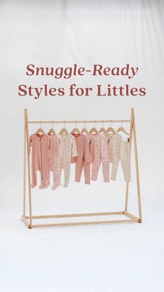 This ad showcases a variety of baby pajamas hanging on a wooden rack.