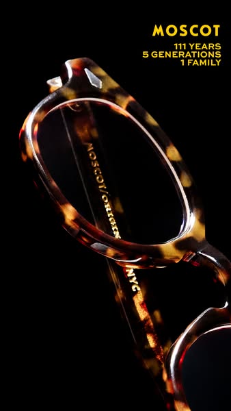 This ad features a close-up of MOSCOT eyeglasses against a black background. The ad uses text to highlight the brand'