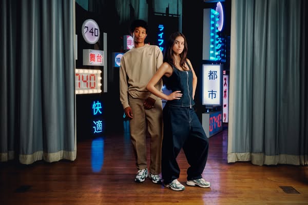 This ad features two models wearing sneakers in front of a backdrop of neon signs. The ad is likely intended to appeal t