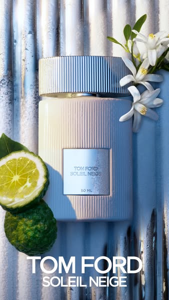 This ad showcases Tom Ford's Soleil Neige fragrance. The image features a bottle of the perfume alongside a sliced l