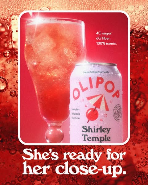 This ad features a can of Olipop's Shirley Temple flavor next to a glass full of the beverage in front of a red back
