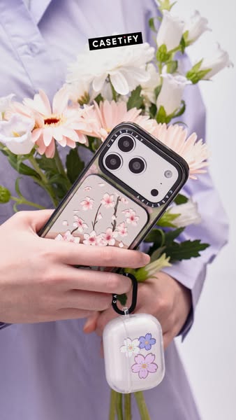 This ad features a hand holding a Casetify phone with a cherry blossom design next to flowers, emphasizing the phone'