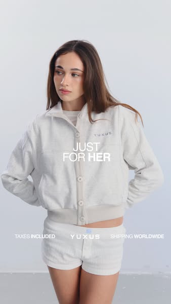 The ad showcases a woman wearing a Yuxus button-down jacket and matching shorts. The ad highlights taxes and shipping ar
