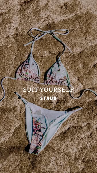 A close up shot of a bikini laid out on the sand from STAUD, accompanied by the text "SUIT YOURSELF STAUD".