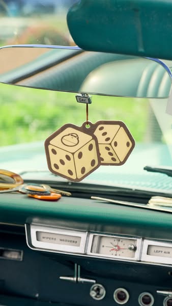 This ad shows an air freshener hanging from the rear-view mirror in a car.